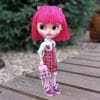 Blythe doll with short bright pink hair, in a school uniform, with a pink backpack