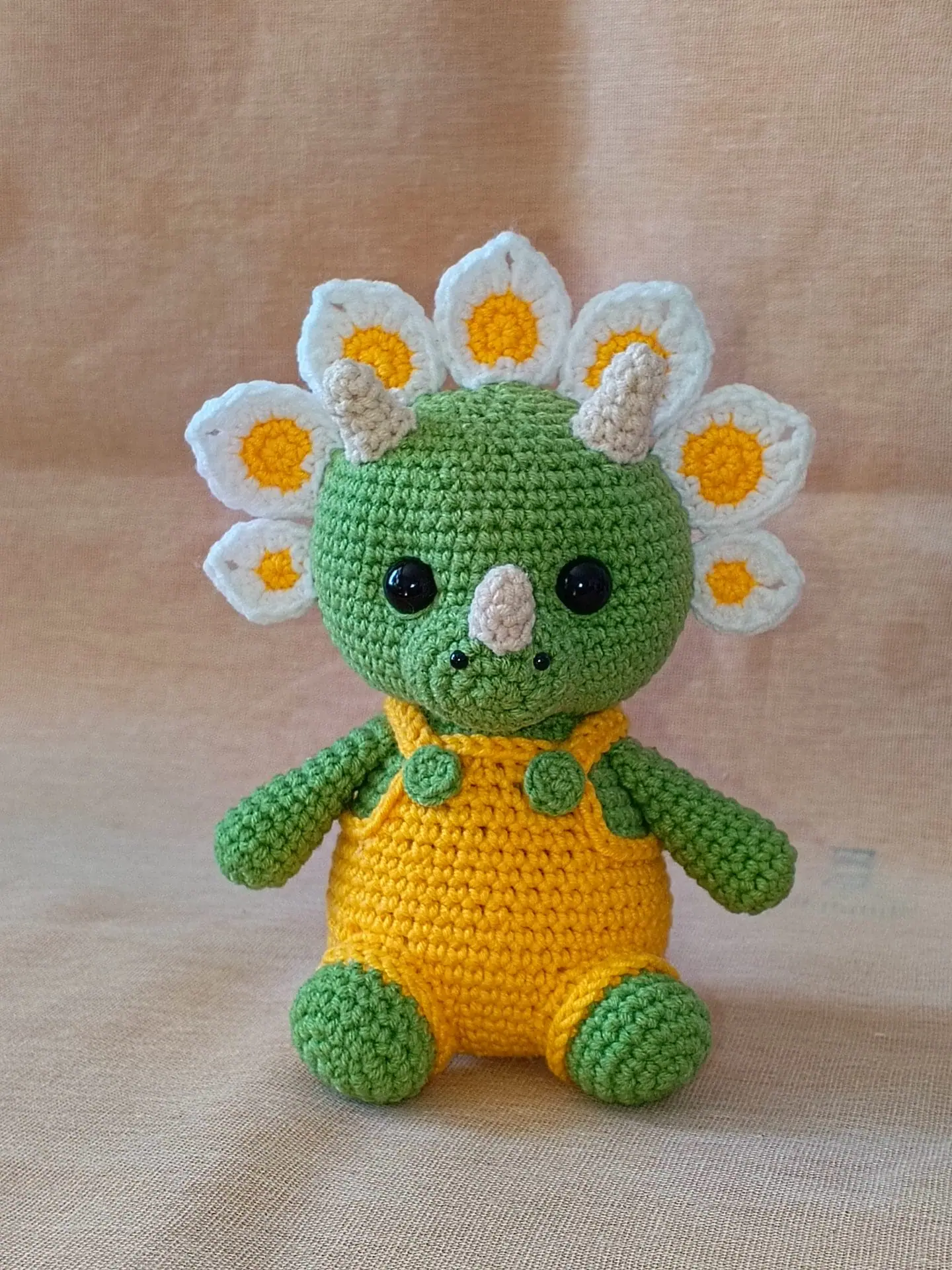 Flowers Dino Crochet Pattern Cute Triceratops Amigurumi Toy 6 Crochet plush amigurumi triceratops dinosaur with daisy flower petals and yellow overalls, digital crochet pattern.