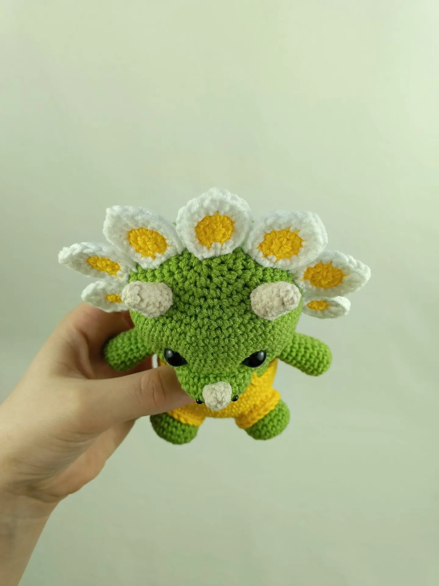 Flowers Dino Crochet Pattern Cute Triceratops Amigurumi Toy 4 Crochet plush amigurumi triceratops dinosaur with daisy flower petals and yellow overalls, digital crochet pattern.