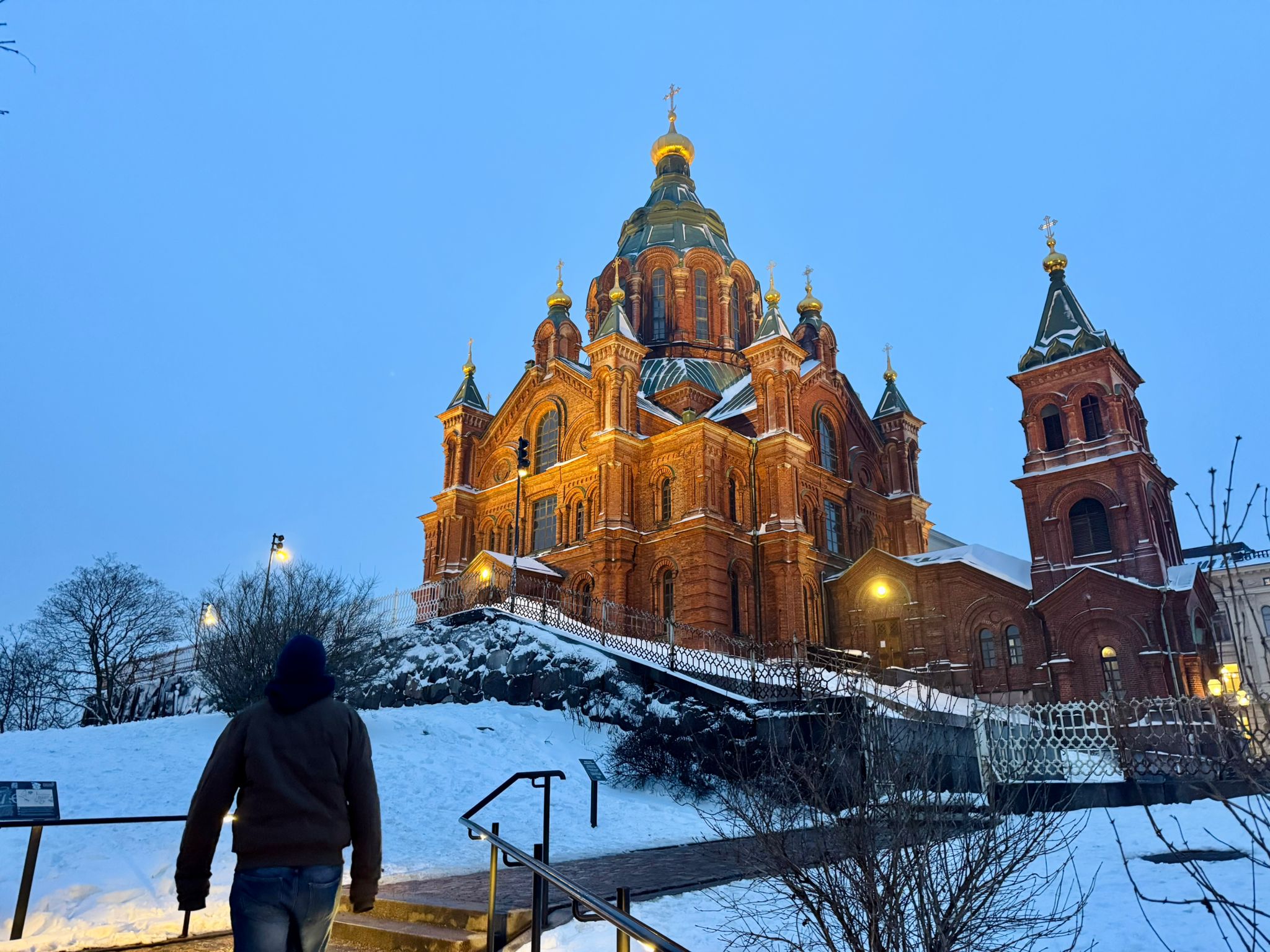 The Uspenskin cathedral in Helsinki. Jonatan is walking up the snow-covered stairs.