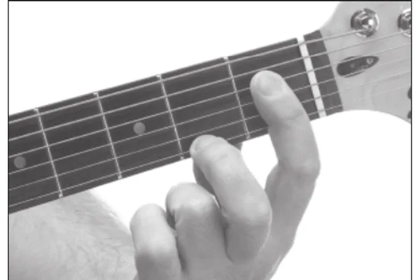 A♭7 chord — a hand playing it on the guitar fretboard