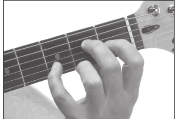 E11 chord — a hand playing it on the guitar fretboard