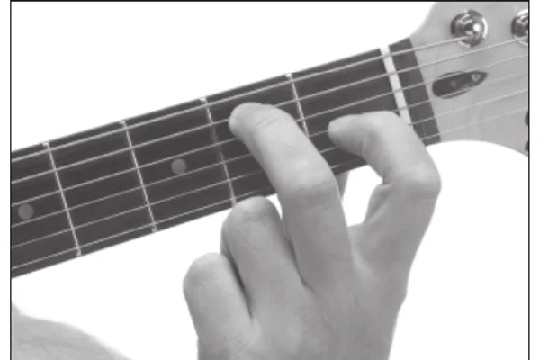 E7 chord — a hand playing it on the guitar fretboard