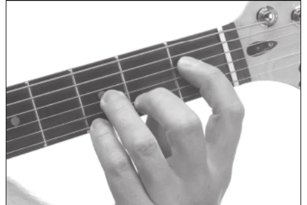 E♭7 chord — a hand playing it on the guitar fretboard