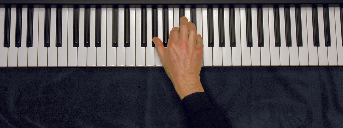 A♭aug chord played on a piano — hand position on the keys