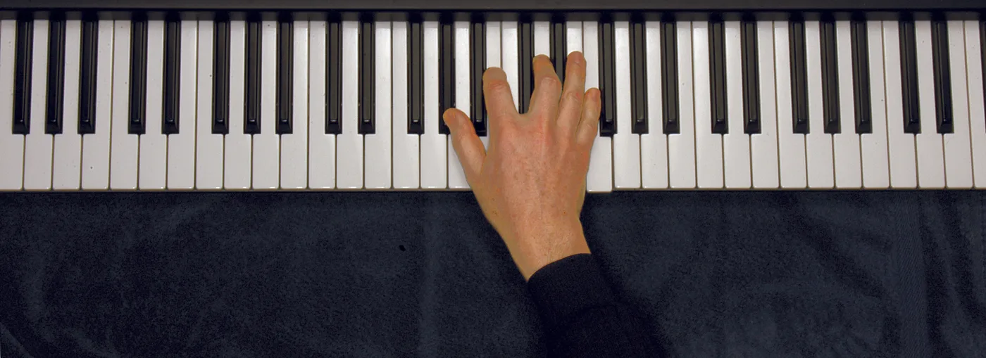A♭dim7 chord played on a piano — hand position on the keys