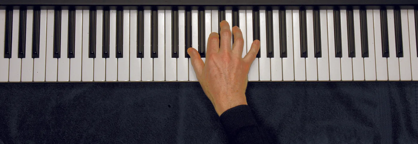 A♭7 chord played on a piano — hand position on the keys