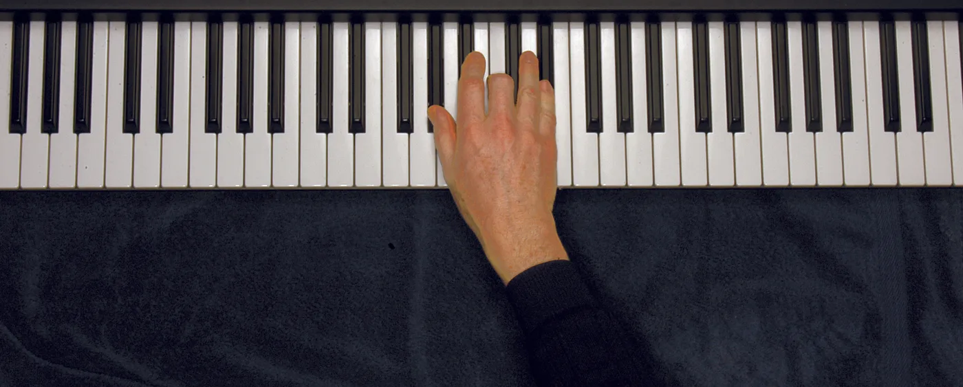 A♭ chord played on a piano — hand position on the keys