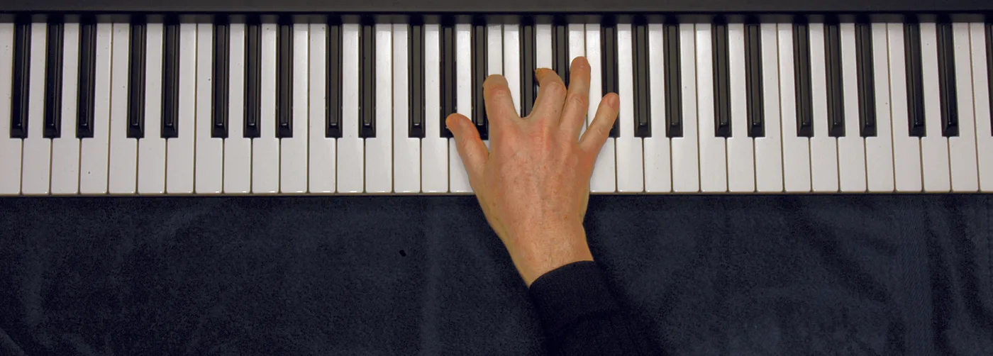A♭m7♭5 chord played on a piano — hand position on the keys