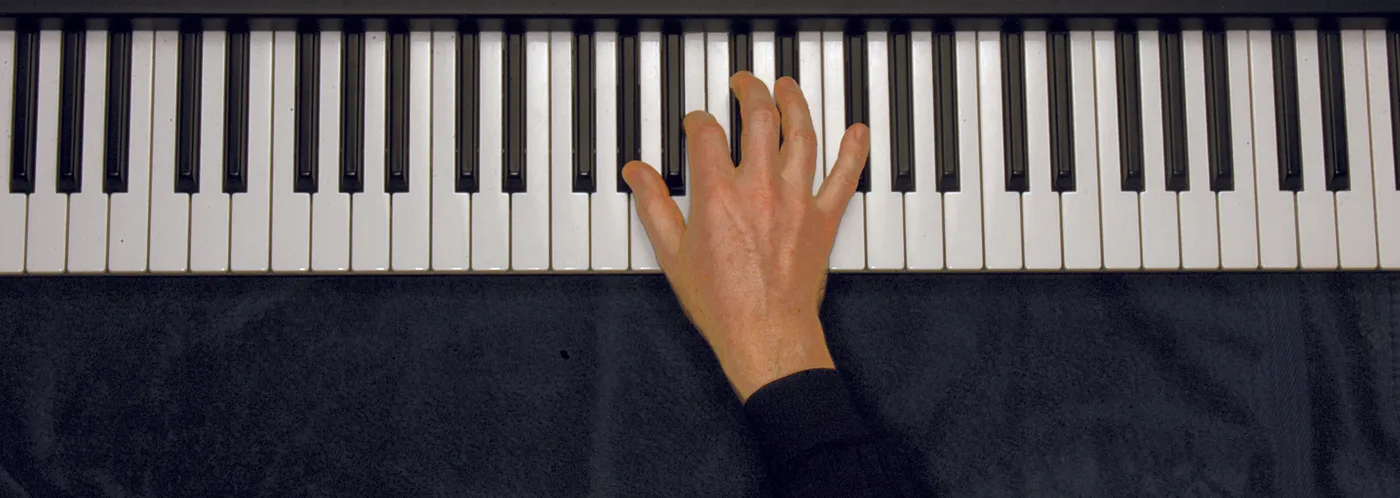 A♭m7 chord played on a piano — hand position on the keys