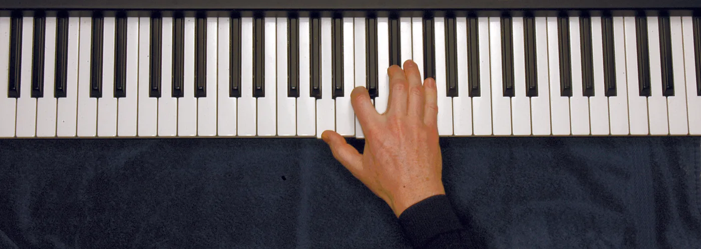 Am7♭5 chord played on a piano — hand position on the keys