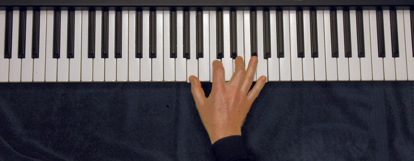 Am7 chord played on a piano — hand position on the keys
