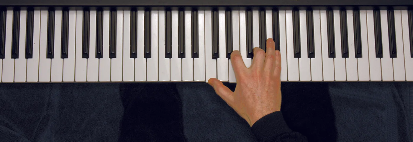 C7 chord played on a piano — hand position on the keys