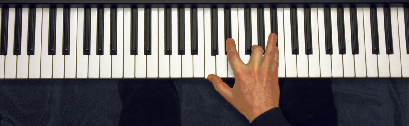 Cm7 chord played on a piano — hand position on the keys