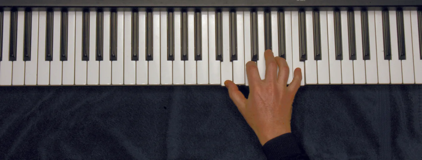 Dm7♭5 chord played on a piano — hand position on the keys