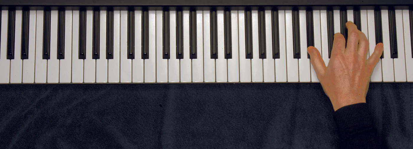 E♭7 chord played on a piano — hand position on the keys
