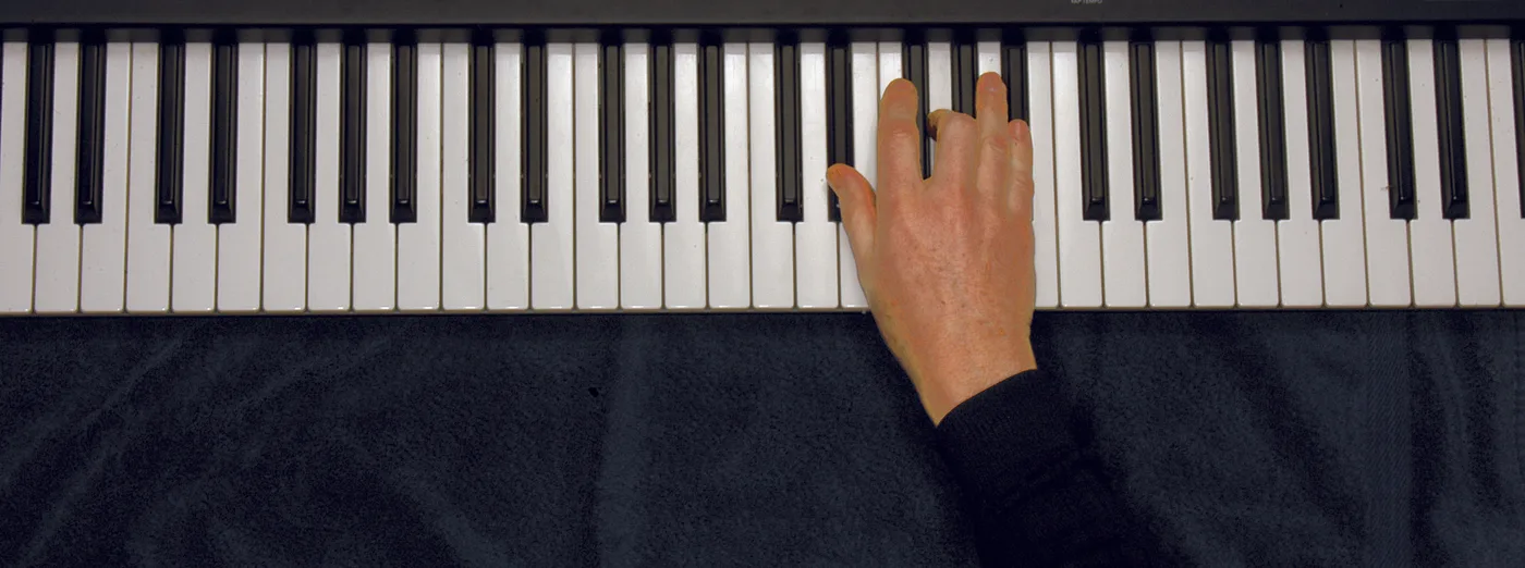 E♭ chord played on a piano — hand position on the keys