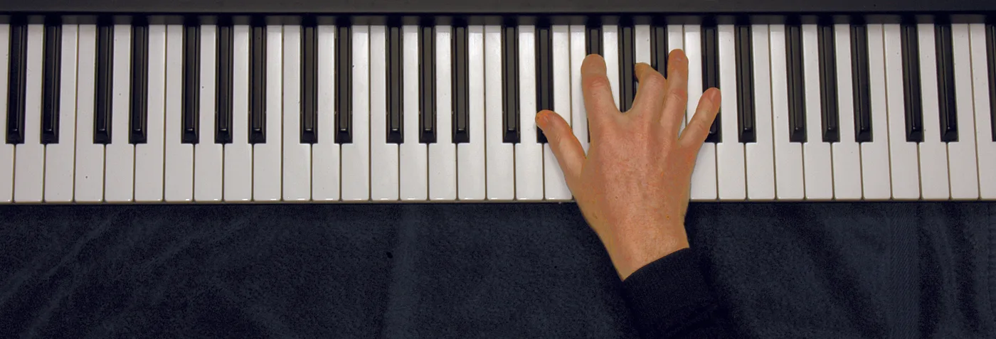 E♭m7♭5 chord played on a piano — hand position on the keys