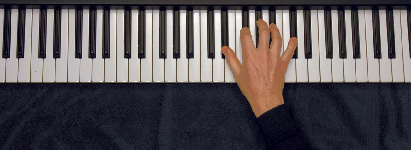 E♭m7 chord played on a piano — hand position on the keys