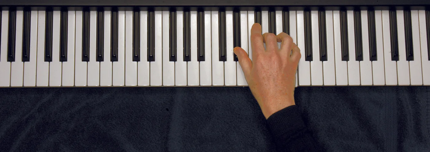 E♭m chord played on a piano — hand position on the keys