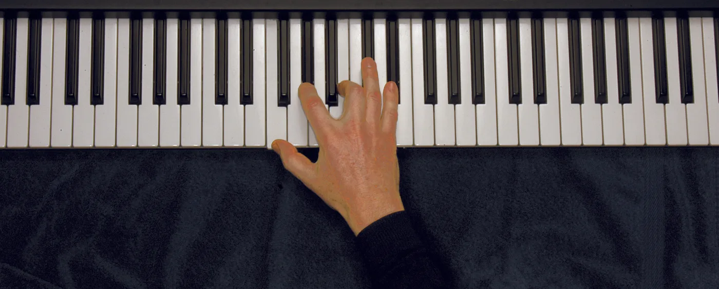 Fm7♭5 chord played on a piano — hand position on the keys