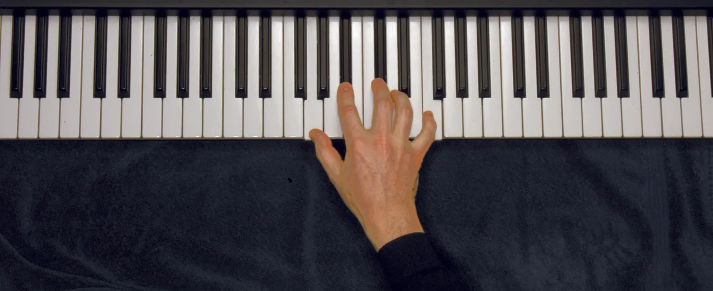 Gm7♭5 chord played on a piano — hand position on the keys