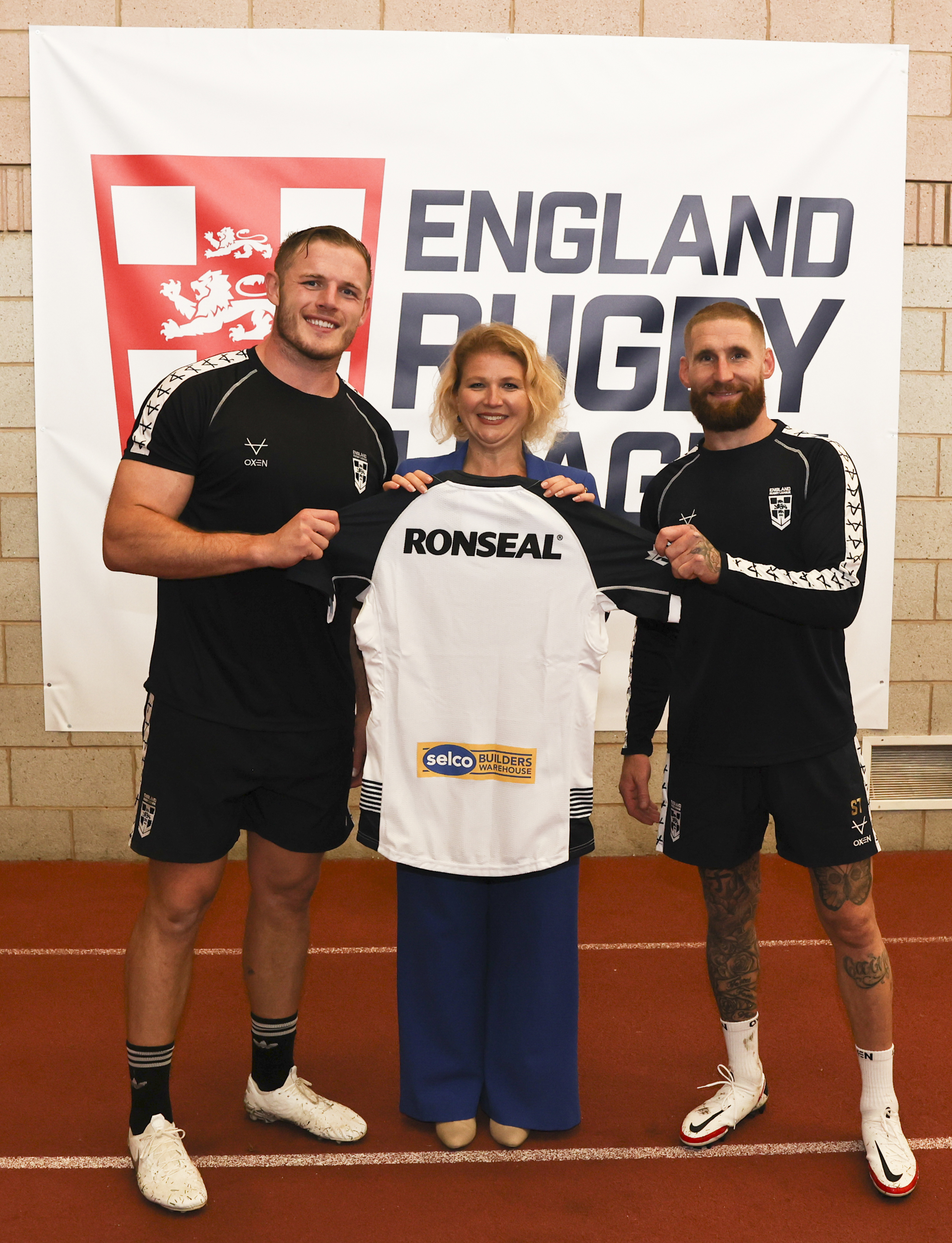 Carine Jessamine, Marketing Director, Selco Builders Warehouse, receiving an England Rugby League jersey from Tom Burgess and captain Sam Tomkins