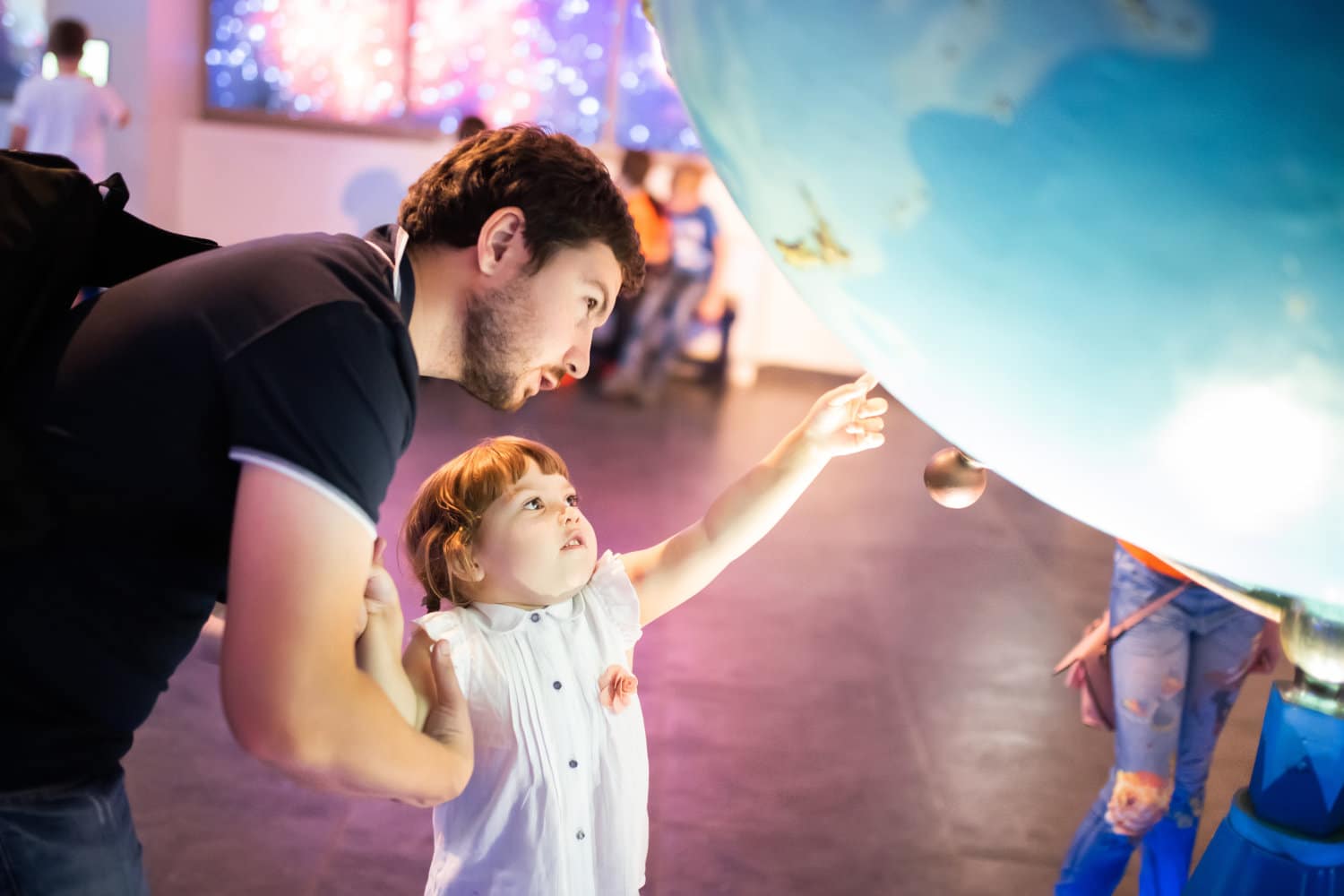 MOSCOW, RUSSIA - JULY 6: Exhibition in Moscow Planetarium. Father and his little daughter looking at the exhibits of the one of the world`s largest planetarium.