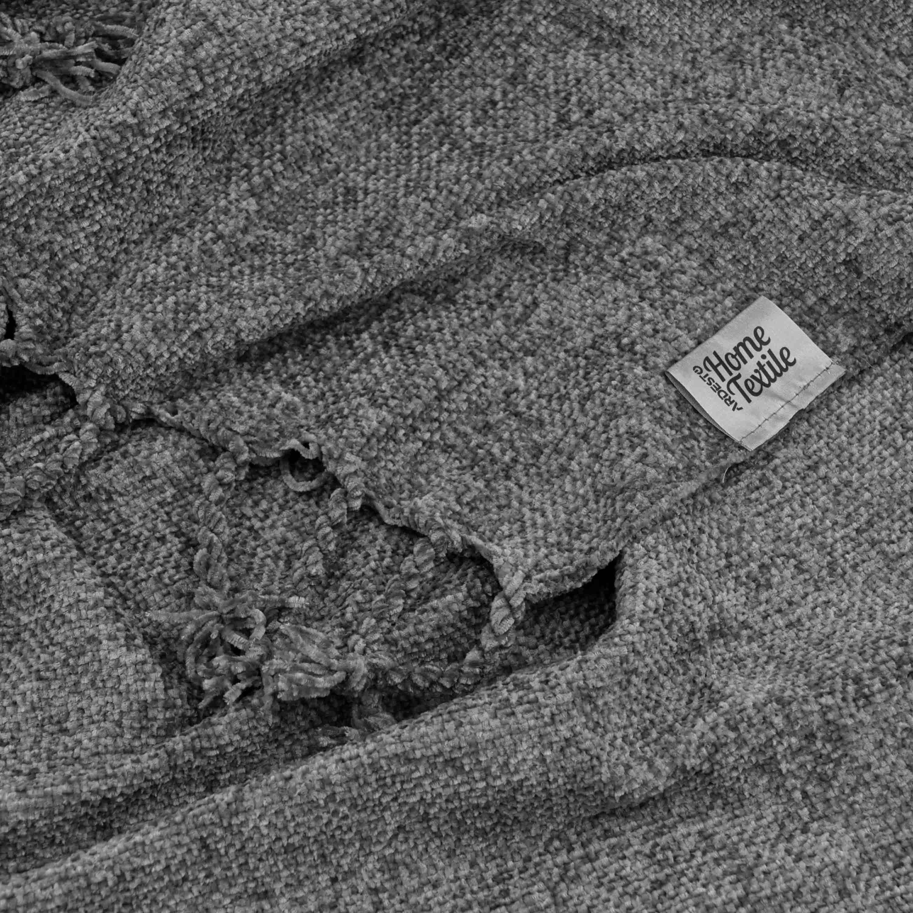 Крупный план темно-серого пледа из микрофибры с бахромой, мягкая текстура