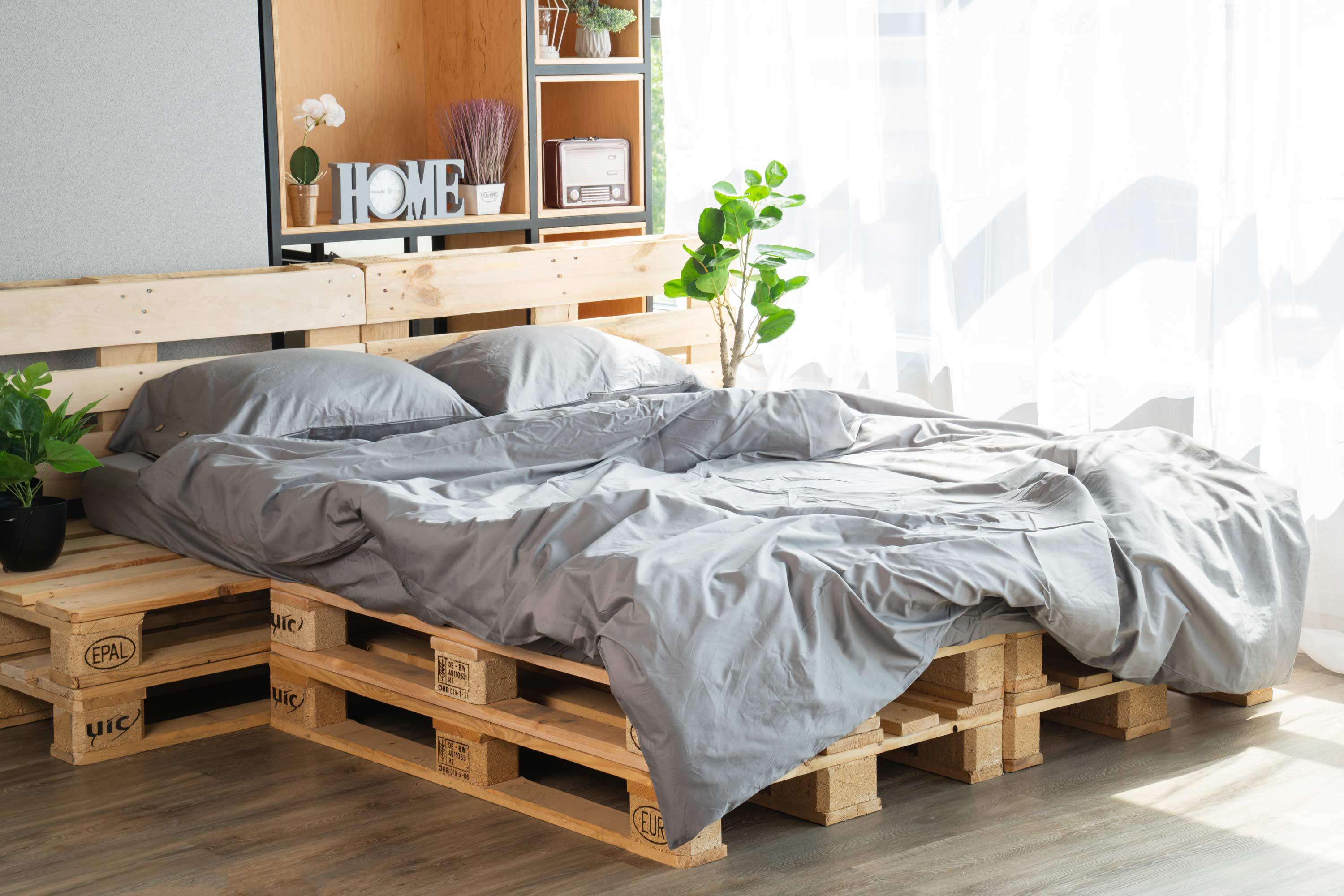 Сатиновая простыня на резинке 180x200+30 серого цвета в интерьере на палетной кровати