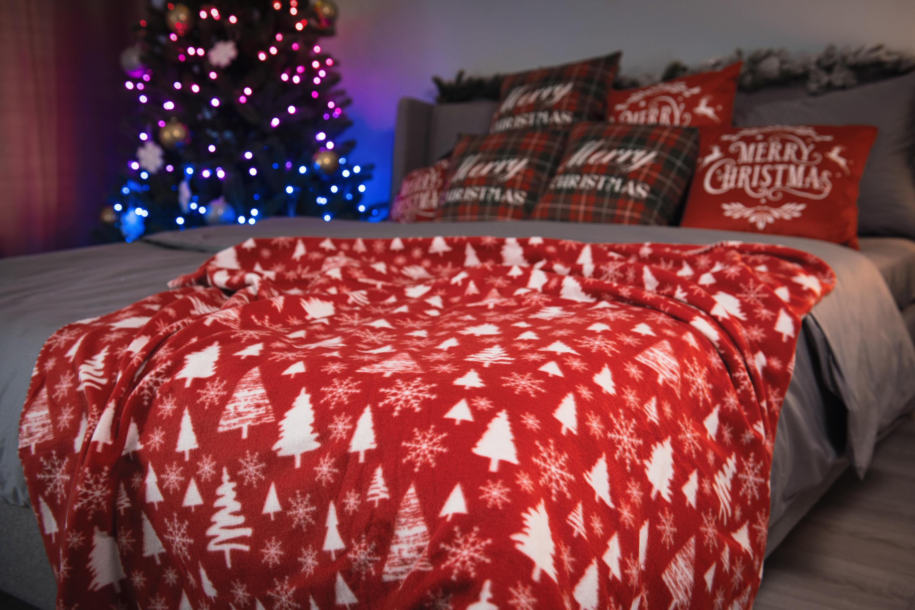 Плед Ardesto Christmas Fleece 130x160 см на ліжку в новорічній спальні