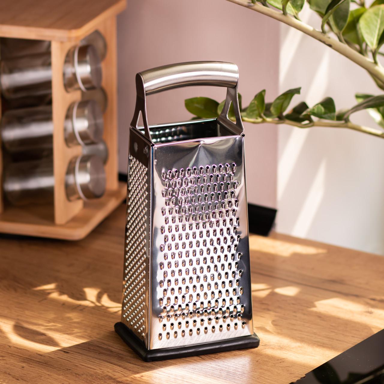 универсальная кухонная терка из нержавеющей стали на деревянной столешнице — терка для овощей и сыра