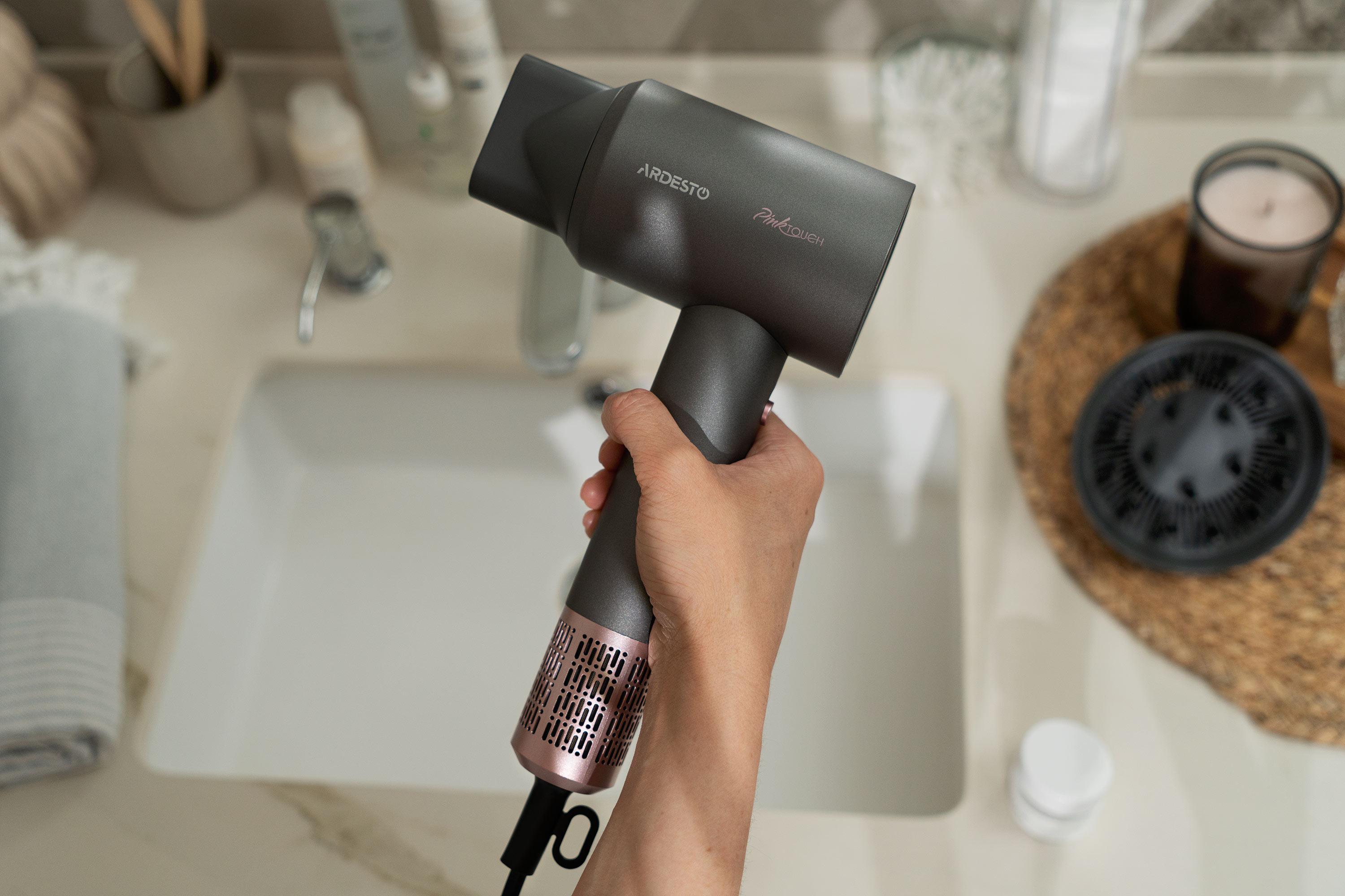 Фен для волос Ardesto Pink Touch с диффузором и концентратором на столе в ванной комнате