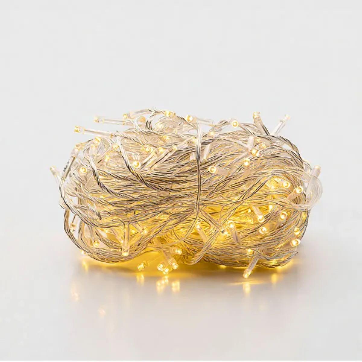 нить светодиодная тёплый свет 22 м — крупный план светящихся диодов на белом фоне